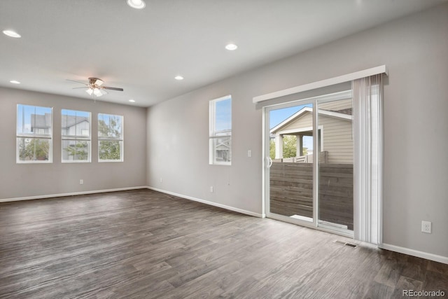 empty room featuring ceiling fan, visible vents, dark wood finished floors, baseboards, and recessed lighting