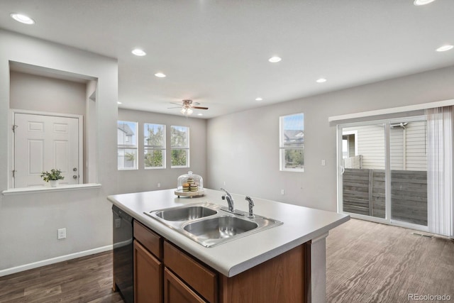 kitchen featuring light countertops, dark wood-style floors, a sink, and dishwasher
