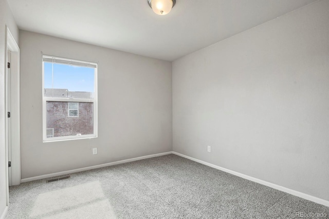 unfurnished room with baseboards, carpet flooring, and visible vents