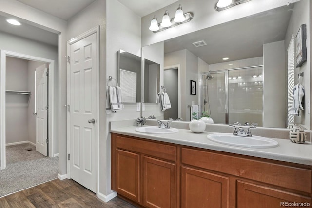 4770 N Jasper St, Denver, CO 80239 - full bathroom with a shower stall, a closet, wood finished floors, double vanity, and baseboards