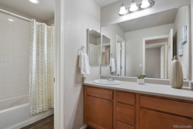 4770 N Jasper St, Denver, CO 80239 - full bathroom with vanity, wood finished floors, shower / bath combo with shower curtain, and a textured wall