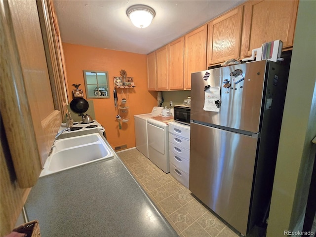 1245 S Forest St, Denver, CO 80246 - kitchen featuring freestanding refrigerator, washing machine and dryer, and light brown cabinetry