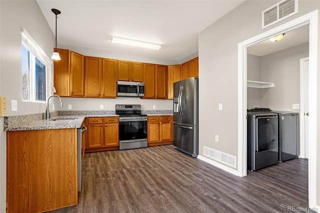 kitchen with visible vents, dark wood finished floors, separate washer and dryer, appliances with stainless steel finishes, and a sink