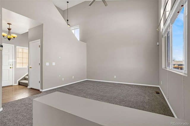 1895 Sage Grouse Ln, Colorado Springs, CO 80951 - empty room with carpet flooring, stairway, a chandelier, baseboards, and a high ceiling