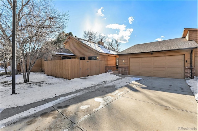 view of snowy exterior featuring a garage