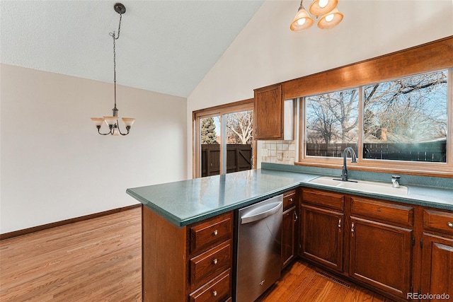 kitchen featuring sink, hanging light fixtures, kitchen peninsula, a notable chandelier, and stainless steel dishwasher