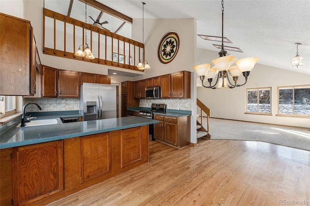 kitchen with stainless steel appliances, pendant lighting, tasteful backsplash, and sink