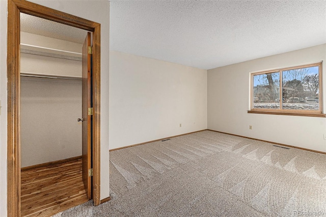 unfurnished bedroom with a textured ceiling, a closet, and carpet