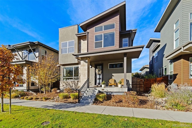 contemporary home featuring a front yard and a porch