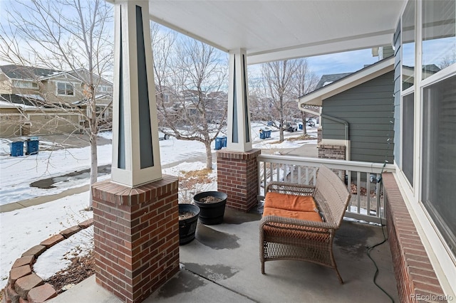 snow covered patio with a porch