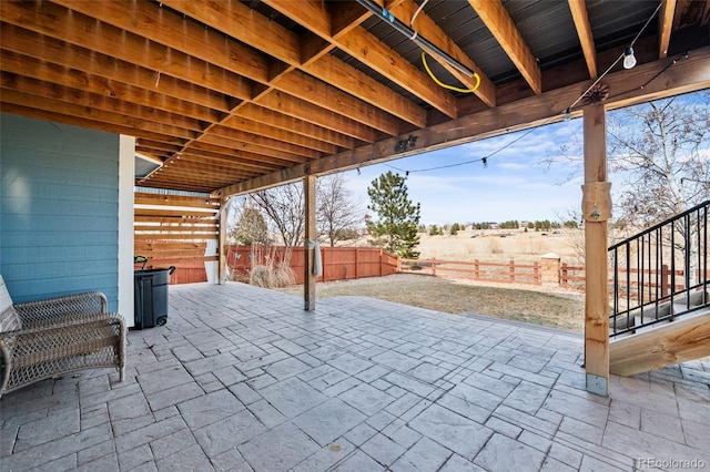 view of patio featuring stairs and fence