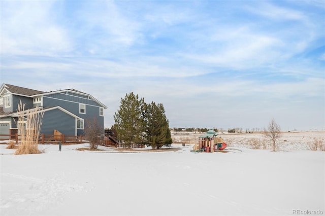 yard layered in snow with a playground