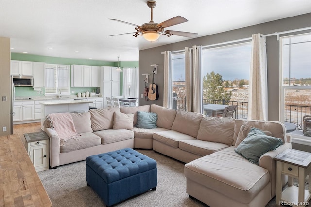 living room featuring recessed lighting, light wood-type flooring, and a ceiling fan