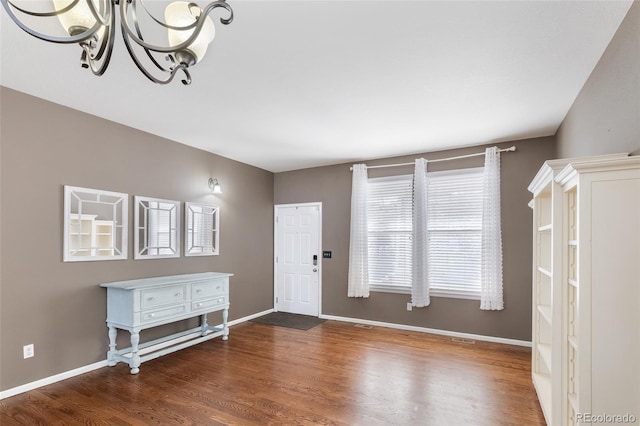 entryway featuring wood finished floors, baseboards, and a chandelier