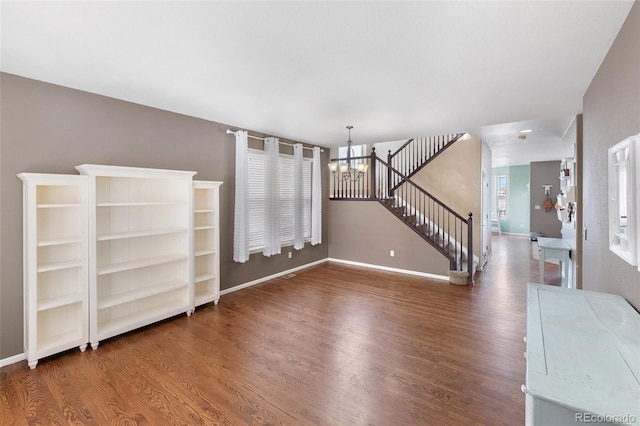 interior space with stairway, baseboards, an inviting chandelier, and wood finished floors