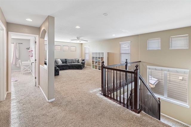 corridor with baseboards, carpet, an upstairs landing, recessed lighting, and arched walkways