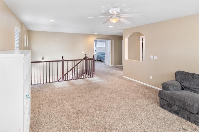 unfurnished room featuring baseboards, carpet floors, recessed lighting, arched walkways, and a ceiling fan