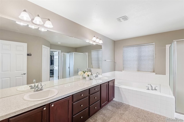 full bathroom featuring double vanity, a stall shower, a garden tub, and a sink