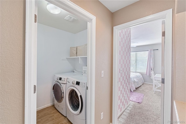 laundry room featuring baseboards, visible vents, laundry area, light colored carpet, and washer and clothes dryer