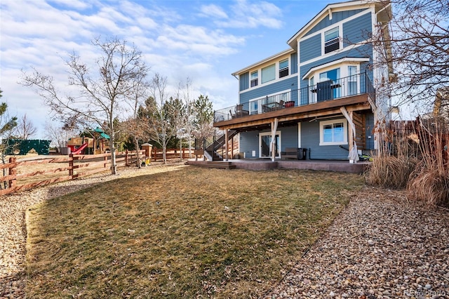 rear view of property featuring playground community, a patio, a lawn, and fence