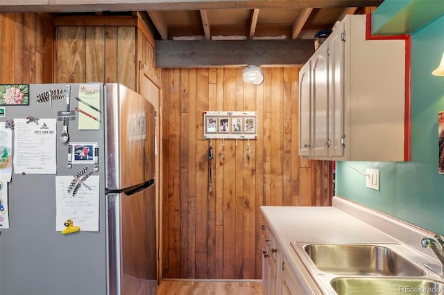 546 Pulver Rd, Lake George, CO 80827 - kitchen featuring freestanding refrigerator, wood walls, light countertops, beamed ceiling, and wood finished floors