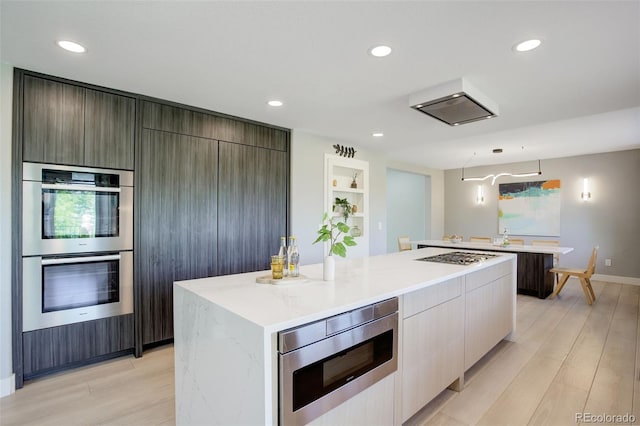 7400 S Genoa Cir, Centennial, CO 80016 - kitchen featuring a large island, stainless steel appliances, modern cabinets, light wood-type flooring, and recessed lighting