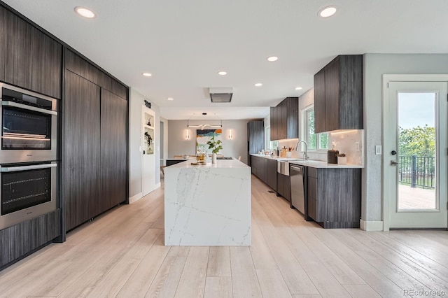 7400 S Genoa Cir, Centennial, CO 80016 - kitchen featuring appliances with stainless steel finishes, modern cabinets, a center island, dark brown cabinetry, and recessed lighting