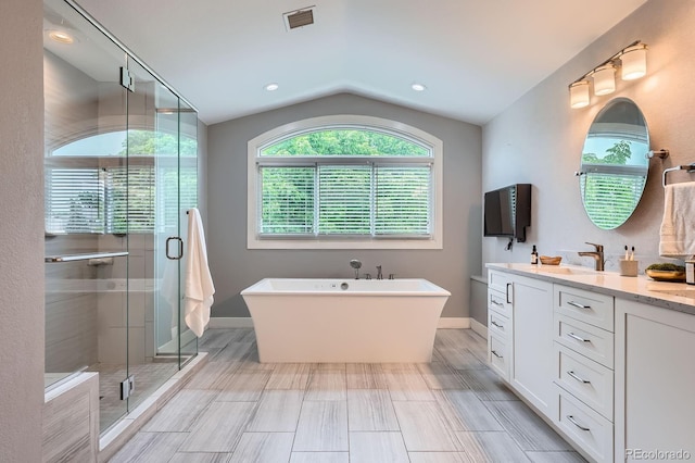 7400 S Genoa Cir, Centennial, CO 80016 - bathroom with double vanity, a freestanding tub, a shower stall, lofted ceiling, and recessed lighting