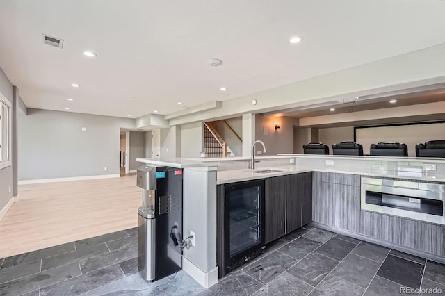 7400 S Genoa Cir, Centennial, CO 80016 - kitchen featuring beverage cooler, open floor plan, light countertops, stainless steel oven, and recessed lighting