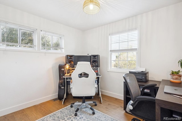 home office with hardwood / wood-style flooring and a healthy amount of sunlight