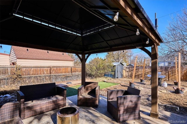 view of patio / terrace featuring a storage shed, a gazebo, grilling area, and an outdoor living space with a fire pit