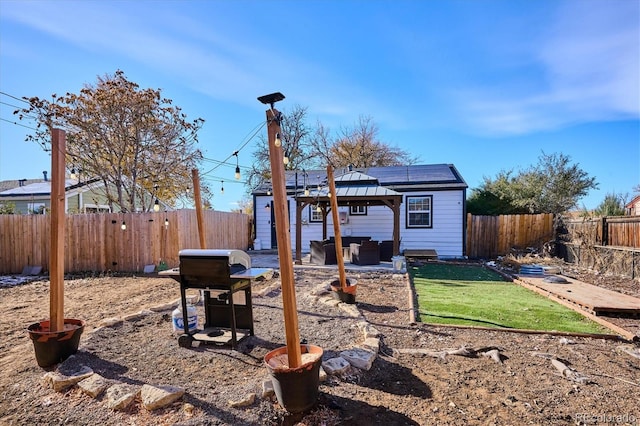 rear view of property featuring a gazebo and an outdoor hangout area