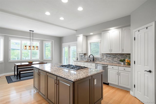 920 Shady Oak Ln, Castle Pines, CO 80108 - kitchen featuring stainless steel appliances, light wood-type flooring, white cabinetry, a sink, and recessed lighting