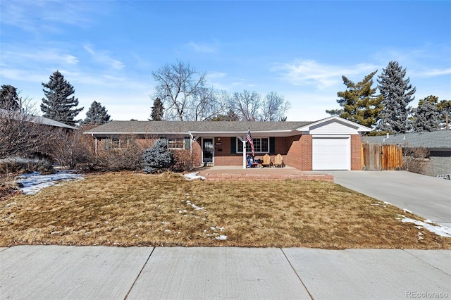 single story home with a garage, a front yard, and a porch