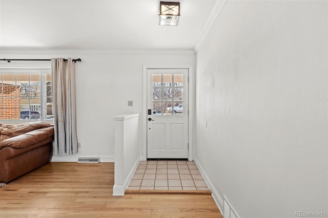 doorway to outside featuring ornamental molding and light wood-type flooring