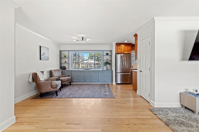 sitting room featuring ornamental molding and light hardwood / wood-style floors