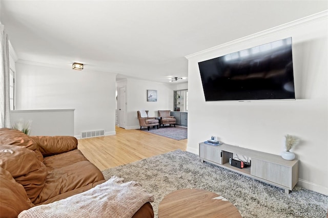 living room featuring hardwood / wood-style flooring and ornamental molding