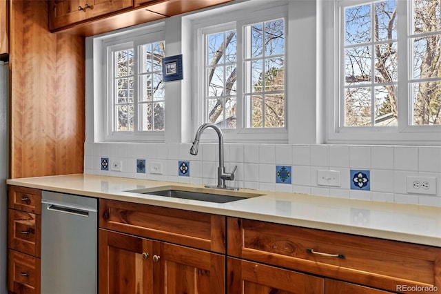 kitchen featuring tasteful backsplash, sink, and stainless steel dishwasher