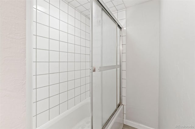 bathroom with shower / bath combination with glass door