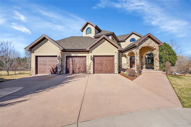 view of front of house featuring roof with shingles, stucco siding, a garage, stone siding, and driveway