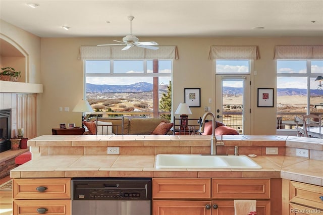 kitchen featuring a sink, tile counters, a mountain view, and dishwasher