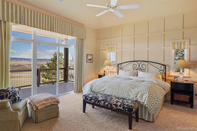 bedroom featuring access to exterior, a decorative wall, and carpet flooring