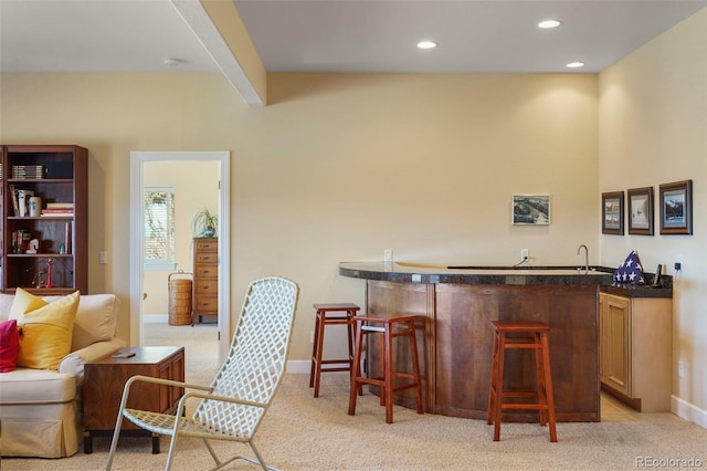 bar with light carpet, recessed lighting, baseboards, and wet bar