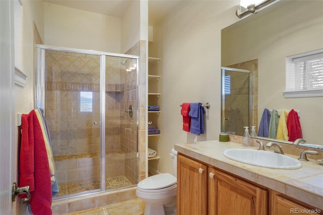 bathroom with toilet, a shower stall, tile patterned flooring, and vanity