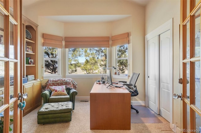 carpeted home office featuring french doors and baseboards