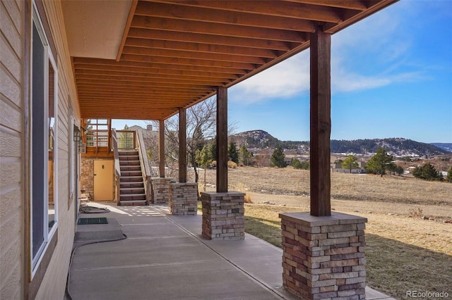 view of patio / terrace featuring a mountain view and stairway