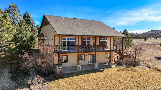 rear view of property featuring a patio area and roof with shingles