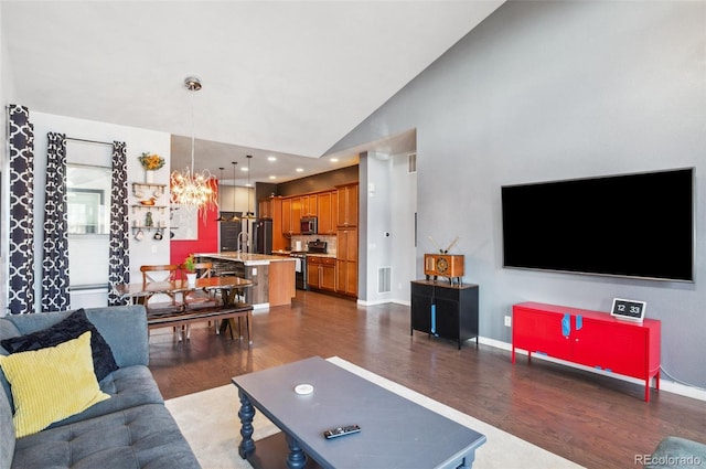 living room with a notable chandelier, vaulted ceiling, and dark wood-type flooring