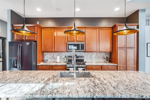 kitchen featuring backsplash, pendant lighting, and appliances with stainless steel finishes