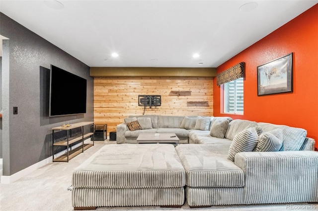 carpeted living room featuring wooden walls